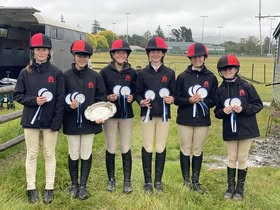Competition team with trophy and rosettes